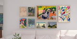 gallery wall with framed artwork including abstract paintings, impressionist landscapes, and classic sketches displayed in a modern living room above a white sofa